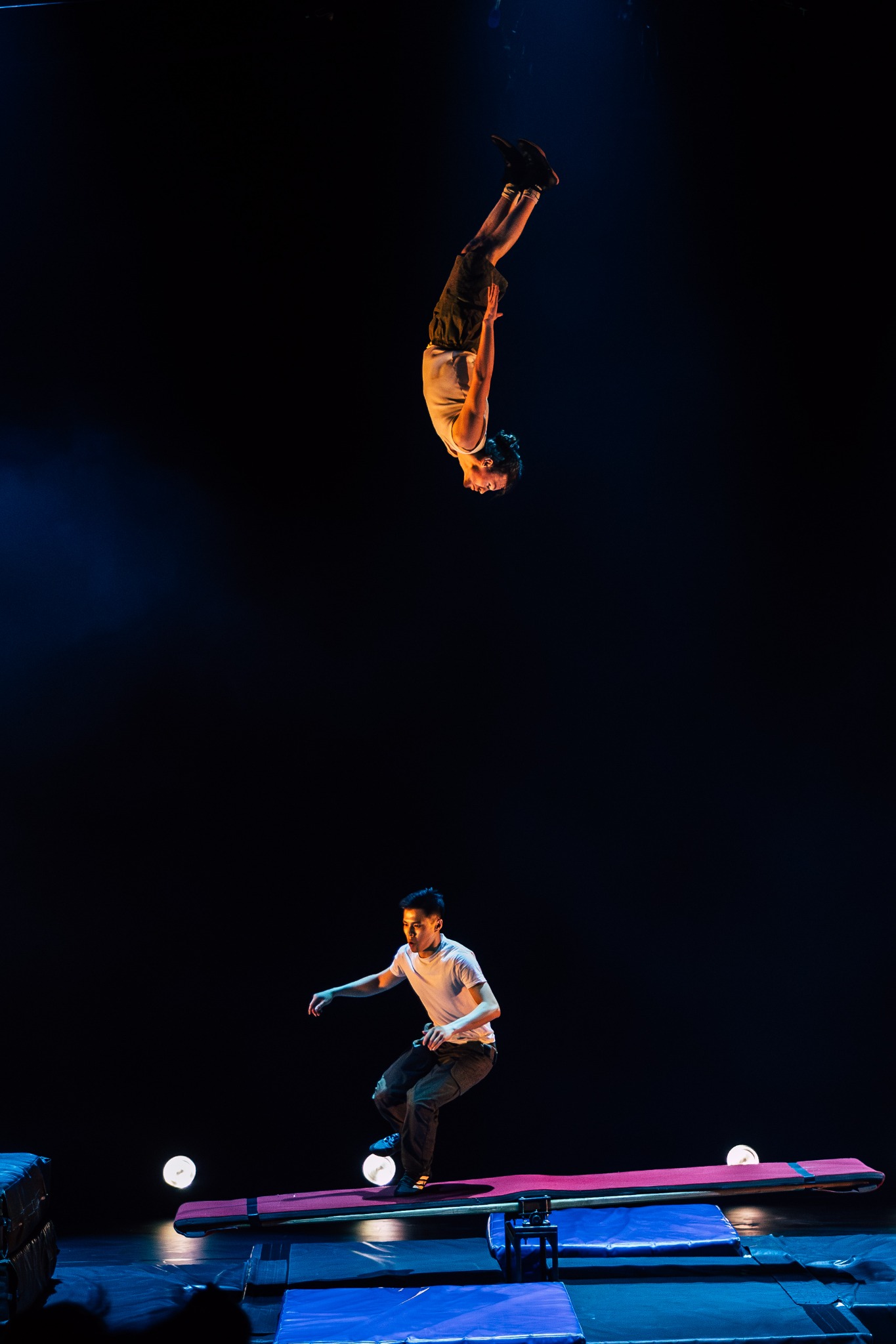 Teeterboard performance with an acrobat high above the stage